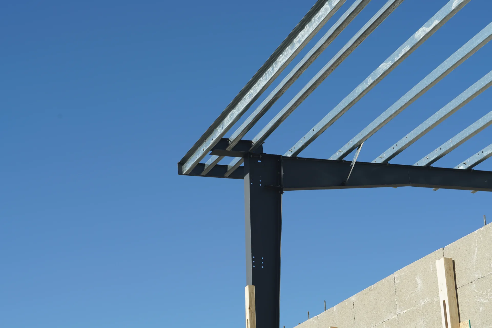 Close view of a bolted moment connection on a red-iron rigid frame with the tapered web visible