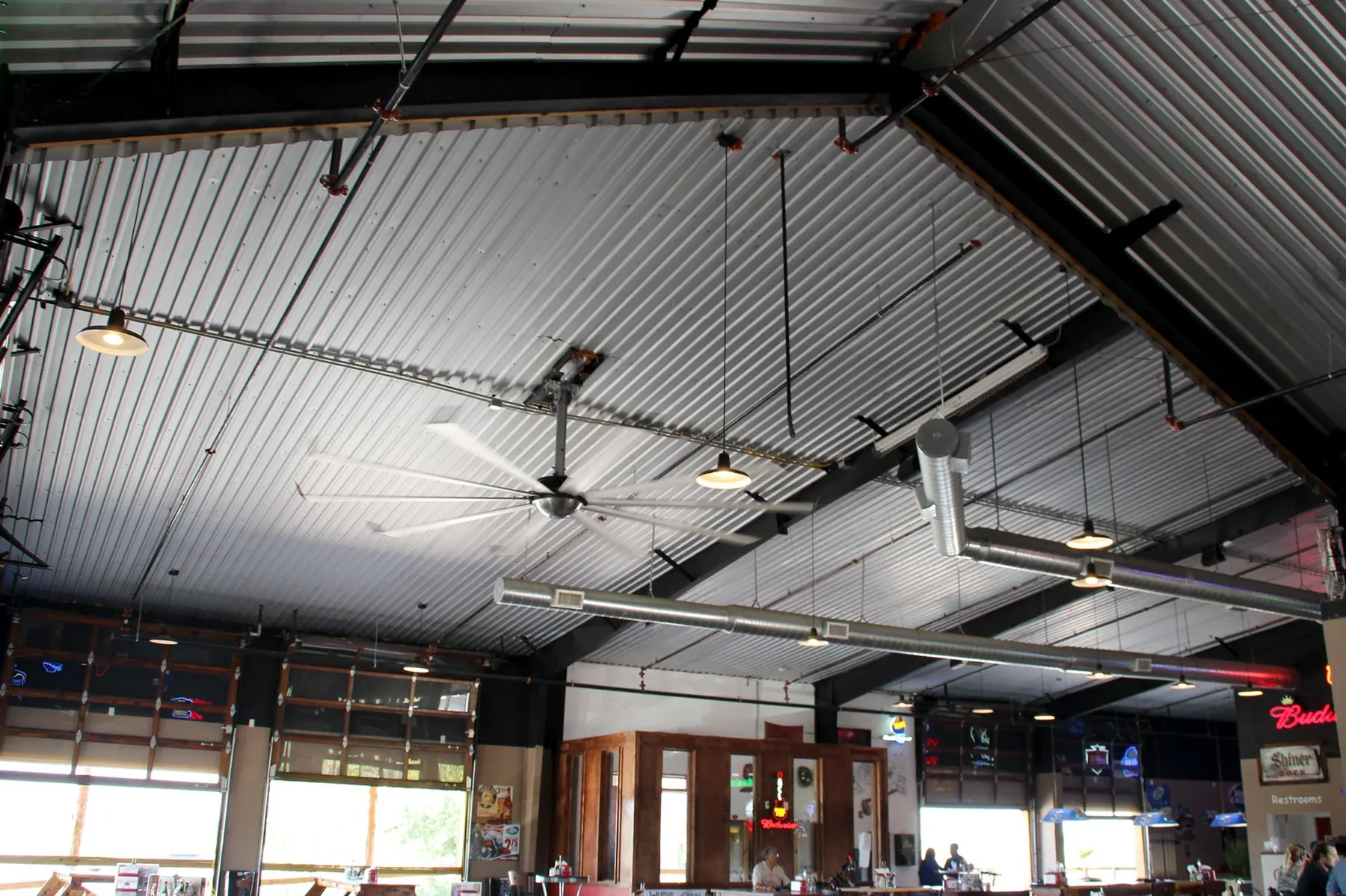 Interior of a commercial metal building showing the exposed roof structure and purlins above an open dining space