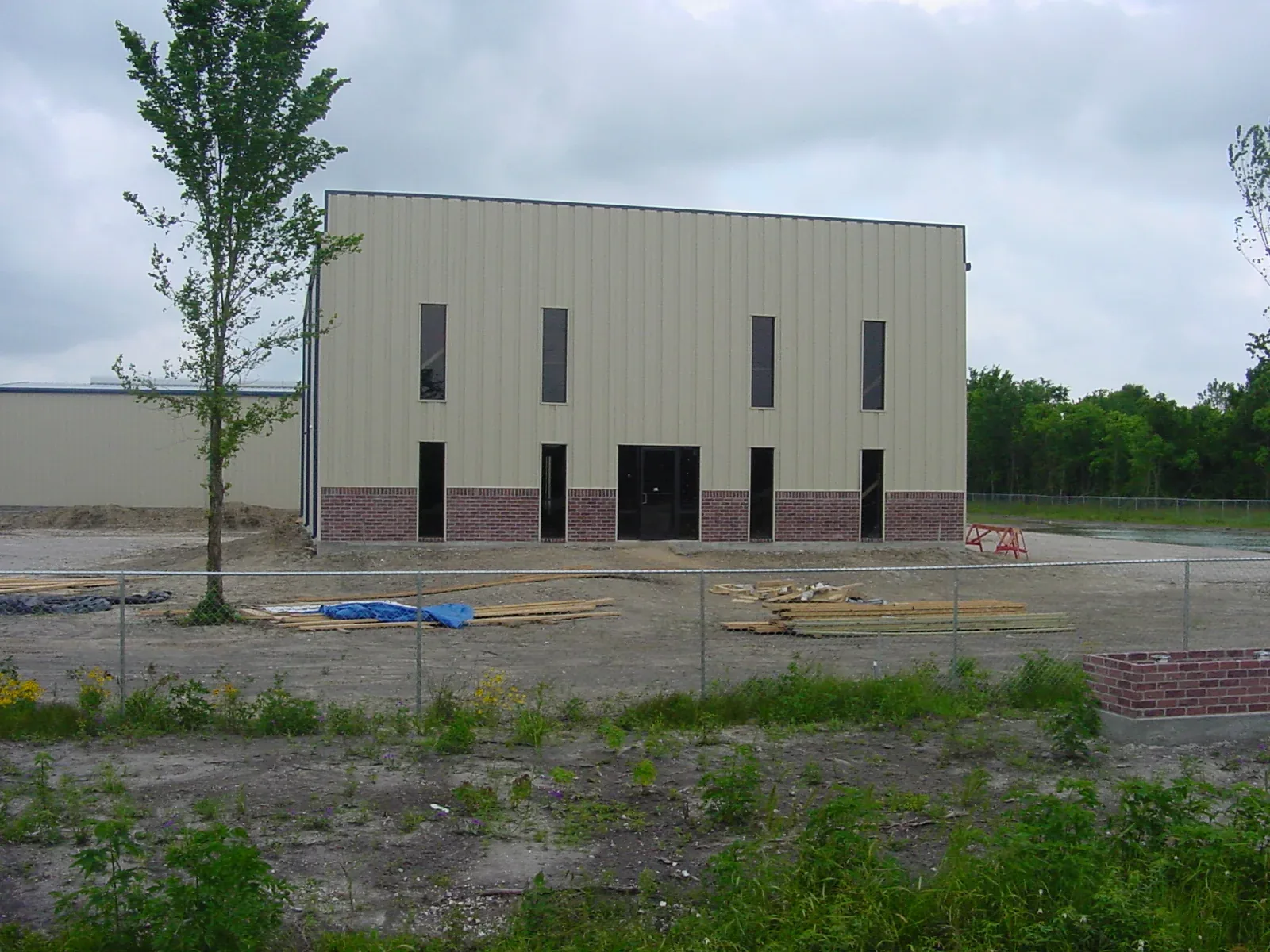 Two-storey commercial metal building with brick wainscot and tall narrow window openings